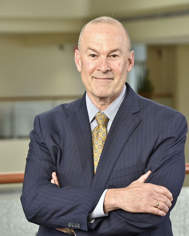 A headshot of Chancellor and Executive Dean, Clay B. Marsh, wearing a suit.